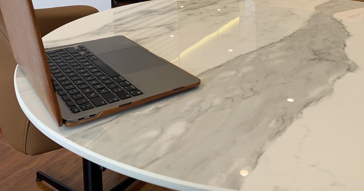 Mesa de mármol con computador portátil en la oficina de Juan Antonio Matiz