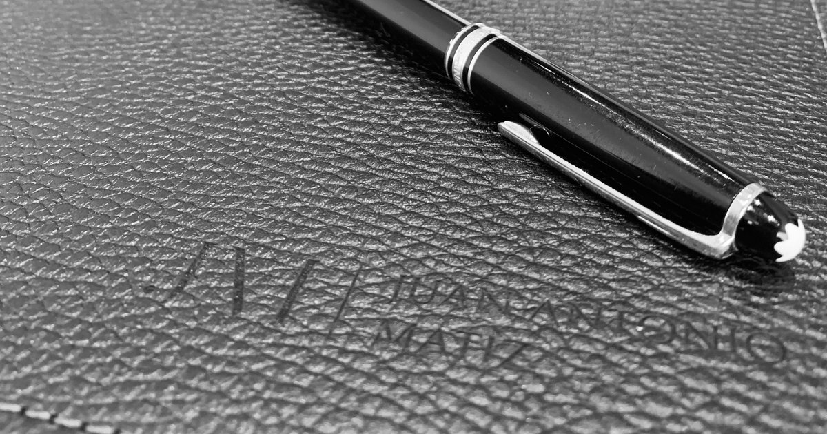 Pluma sobre carpeta de cuero con el logo de Juan Antonio Matiz