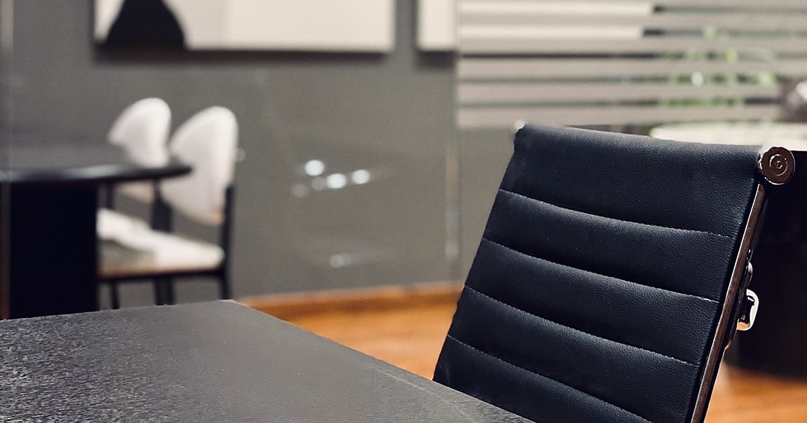 Puesto de trabajo en el despacho de Juan Antonio Matiz: escritorio con carpeta de cuero, silla y sala de reuniones al fondo
